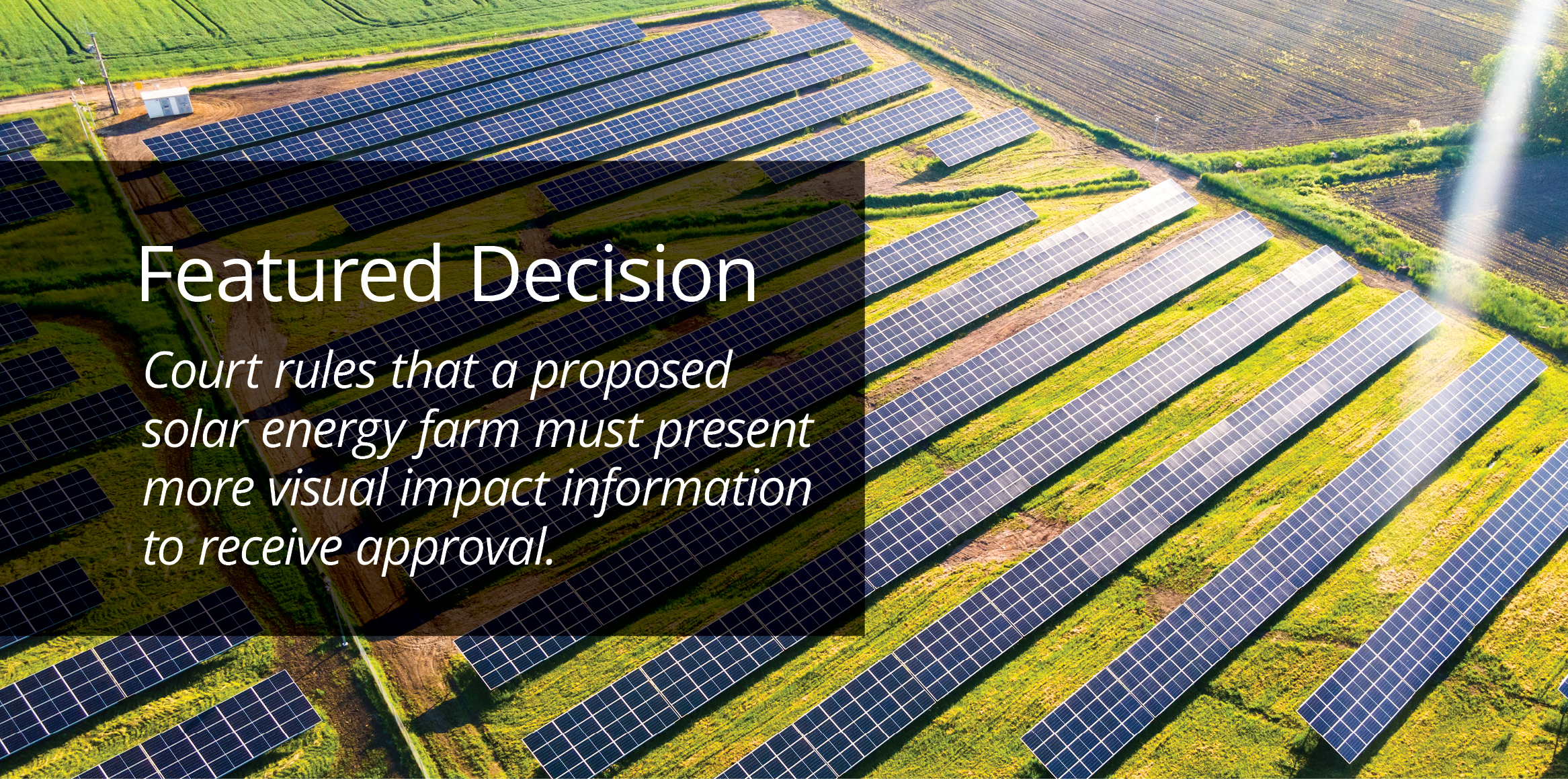 Rows of solar panels on a green field near farmland